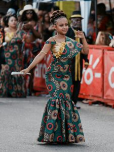 A young woman in a vibrant traditional dress participates in a lively parade in Limón, Costa Rica.