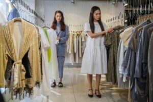 Two women browsing stylish clothes in a modern boutique.
